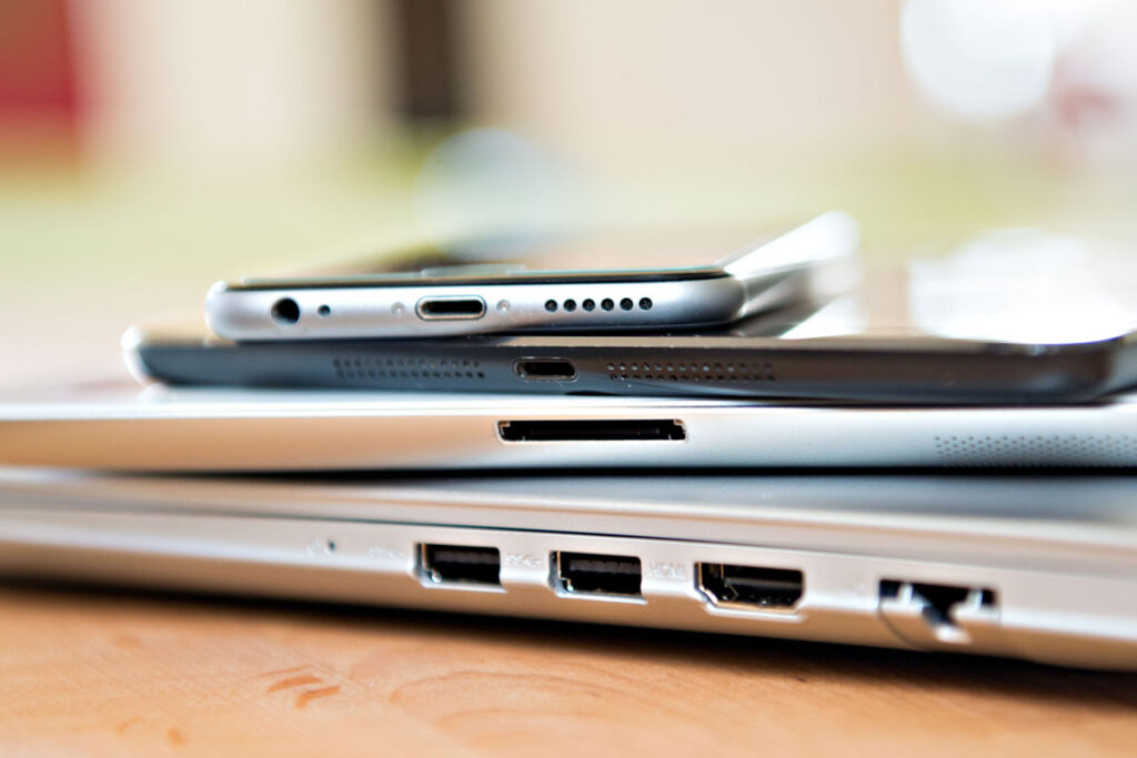 Laptops, tablets and smartphones are stacked on top of one another.