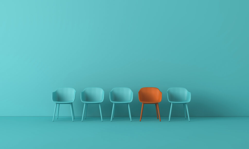 Aqua chairs in a line with one orange chair